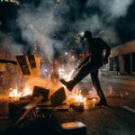 man in black t-shirt and black pants holding fire